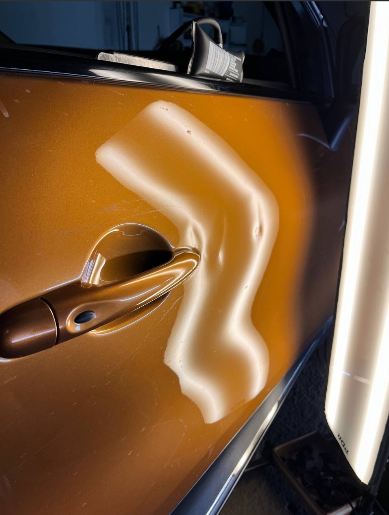 Poškození dveří u kliky před opravou